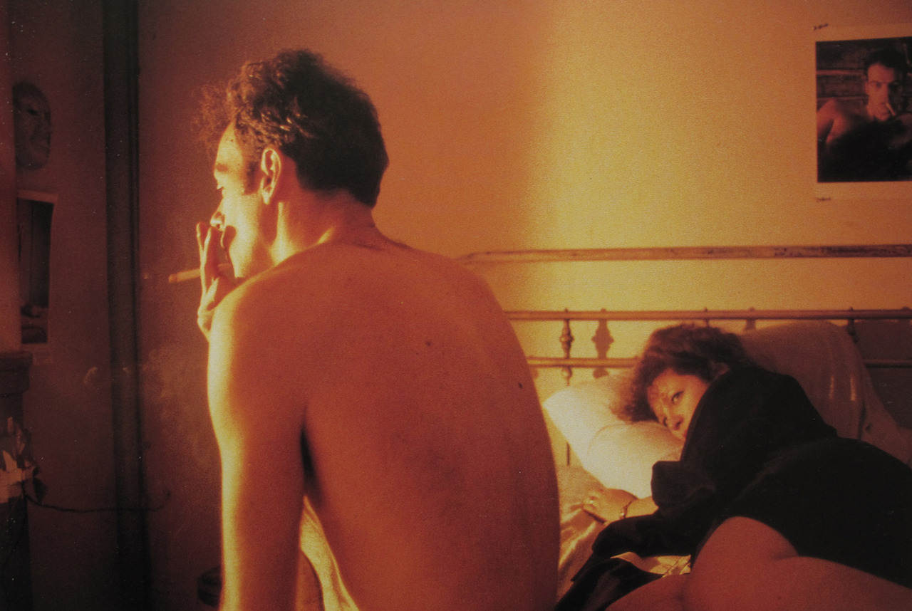 Hombre sentado en una cama fumando. Proyectos de amor en el arte
