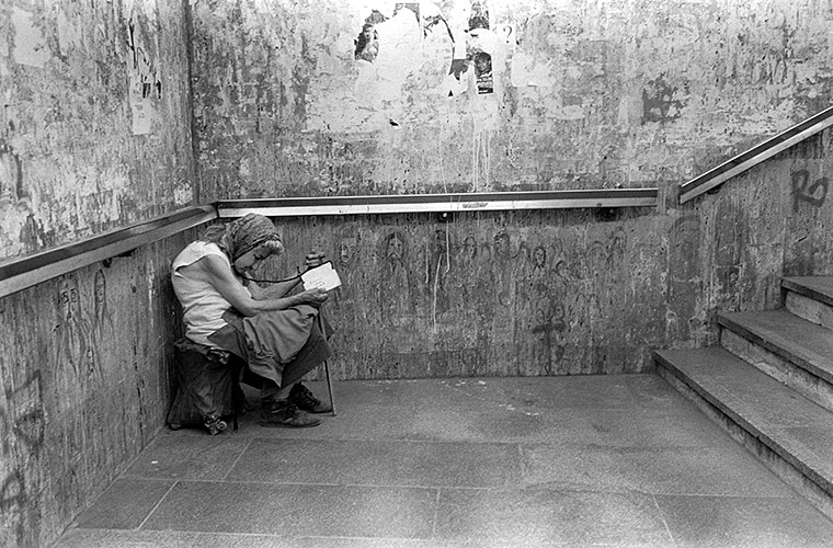 Mujer pidiendo limosna en un pasillo. Peter Kayafas. 