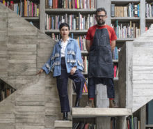 Dos personas paradas sobre escaleras de concreto. Pedro Reyes y Carla Fernández.