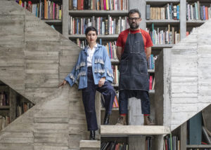 Dos personas paradas sobre escaleras de concreto. Pedro Reyes y Carla Fernández.