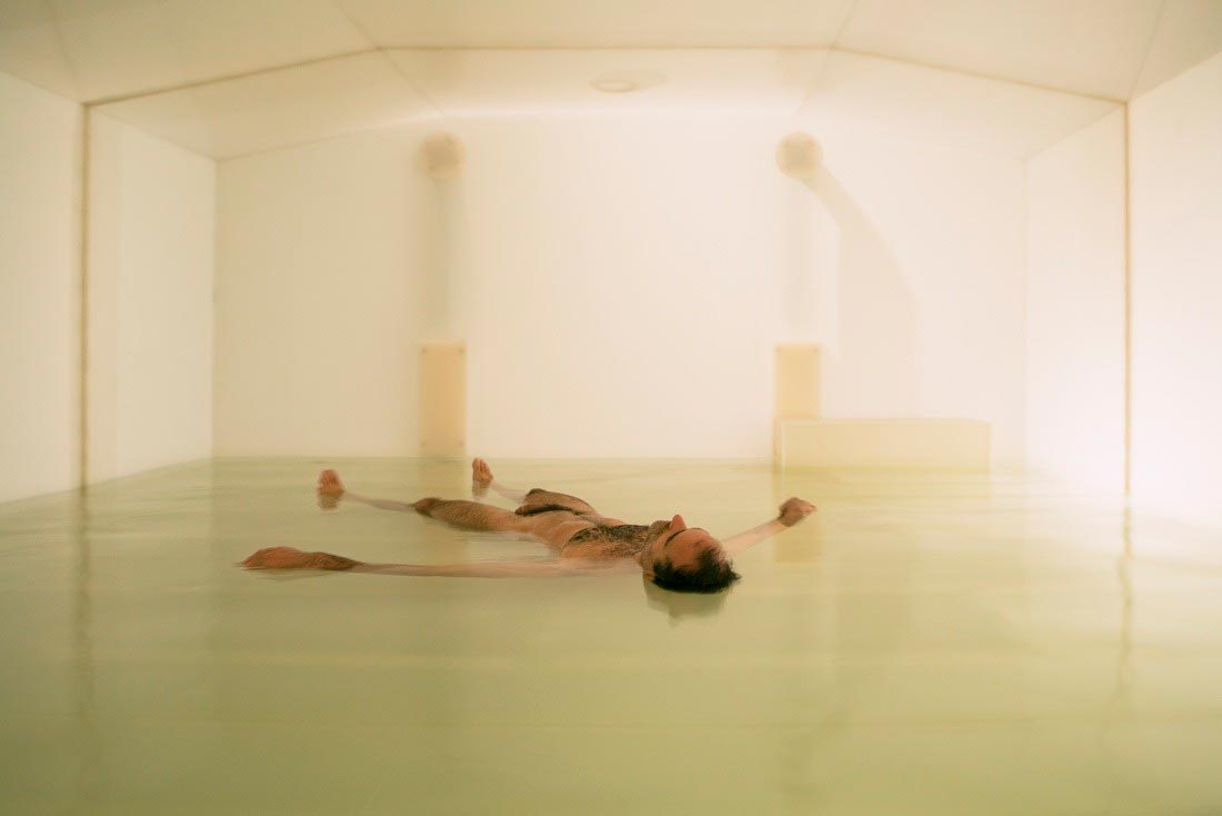 Hombre flotando sobre agua en un tanque. Obras de Carsten Höller. 