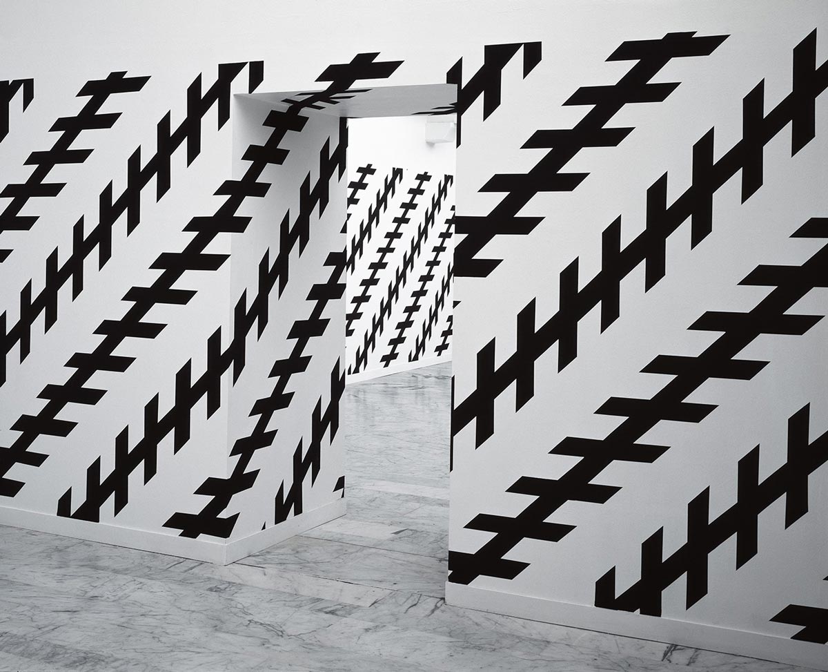 Líneas diagonales negras sobre muros de galería. Obras de Carsten Höller. 