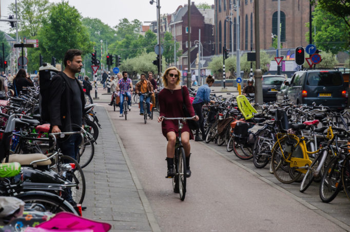 Chica en bicicleta sobre una calle de Ámsterdam.